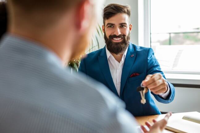 Landlord giving tenant keys, covered by landlord insurance